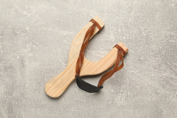Slingshot with leather pouch on light grey background, top view