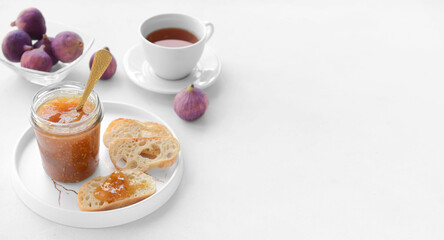 Toasts, sweet fig jam and cup of tea on white background with space for text