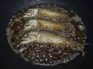 Fried mackerel in boiling oil
