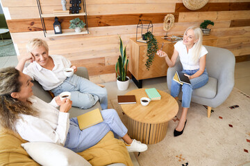 Mature women taking part in book club at home