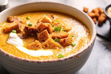 Bowl of tasty cream soup with croutons on table