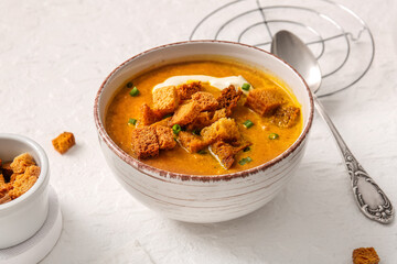 Bowl of tasty cream soup with croutons on white background