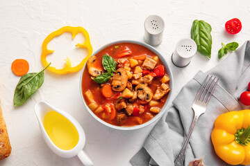 Bowl of tasty beef stew and ingredients on white background