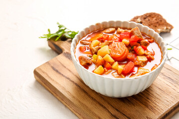 Bowl of tasty beef stew on white background