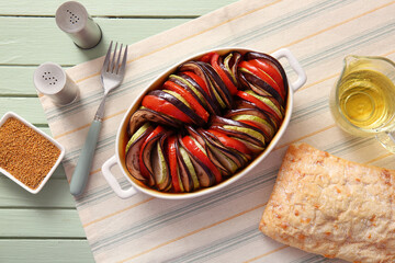 Baking dish of tasty Ratatouille on green wooden background