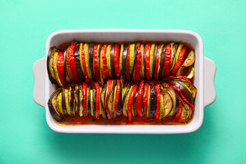 Baking dish of tasty Ratatouille on turquoise background