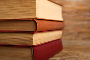 Stack of old hardcover books on wooden background, closeup