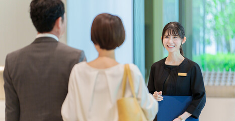 カップルの案内をする女性従業員