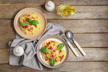 Plates with tasty pasta carbonara on wooden background