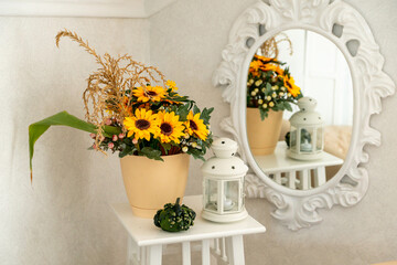 Autumn composition with a bouquet, a lantern and pumpkin in the interior of a bright living room