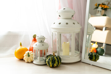 Autumn composition with lanterns and pumpkins in the interior of a bright living room