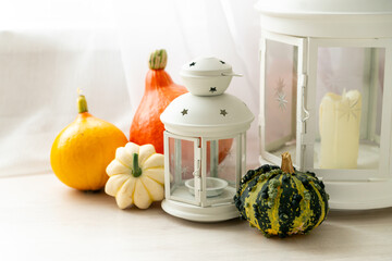 Autumn composition with lanterns and pumpkins in the interior of a bright living room