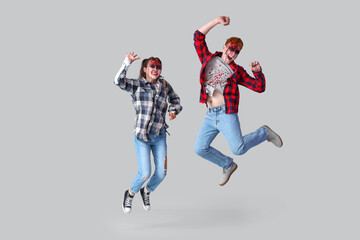 Scary zombies jumping on grey background
