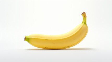 Generate a mouthwatering depiction of a ripe, yellow banana, its natural curves and soft tones illuminated on a clean white surface.
