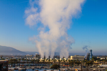 Fototapeta premium Steam power plant in the city with turbine tower with smoke