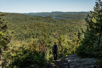 Girl hiking in the Forest near lake in La Mauricie National Park Quebec, Canada on a beautiful day - 647927699