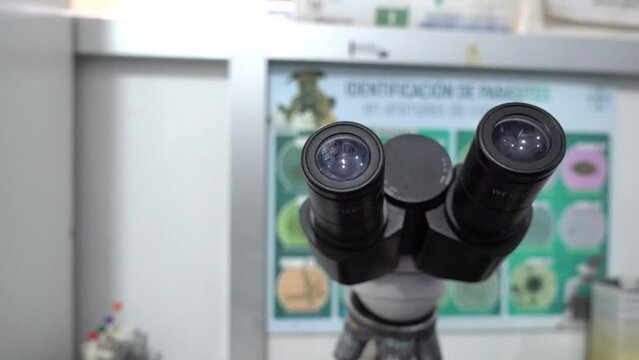 Slow rotating shot around the eyepieces of a microscope in a veterinary clinic