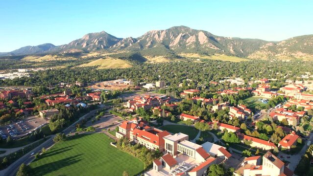 Drone flying the University of Colorado Boulder (CU Boulder), with the flatirons and the town of Boulder in the background. Colorado University Campus on a Summer morning.