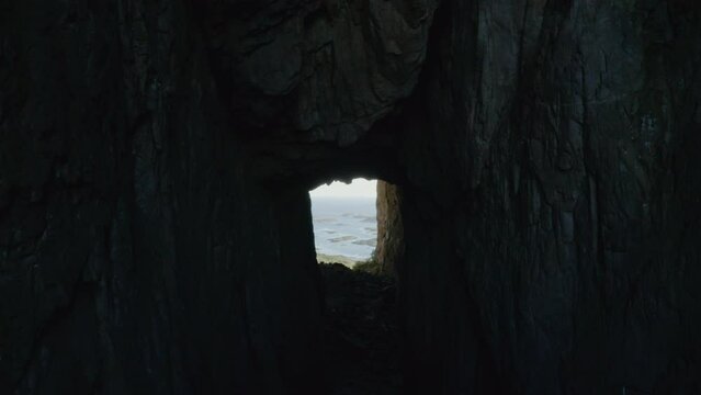Architectural exploration of Torghatten, Norway: dark cave-like arch amidst stunning landscapes.
Mystical Norwegian mountain arch with dark cave, aerial view.