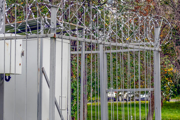 Metal fence with barbed wire on an autumn day