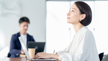 Fototapeta premium フリースペースでパソコンに向かう女性