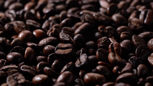 Close-up video of roasted coffee beans. Move to the side.