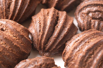 chocolate choux on a pink plate. Sweet pastry is made from wheat flour, eggs, chocolate, sugar. blurred image.