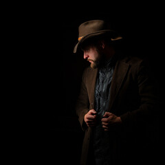 Portrait of a sad cowboy on dark background