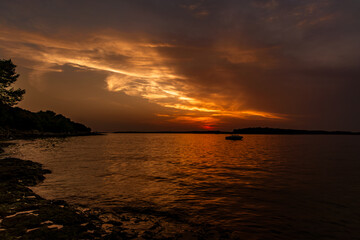 A boat against the background of the setting sun in Pula