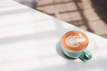 Coffee latte on white table, latte art at the coffee shop
