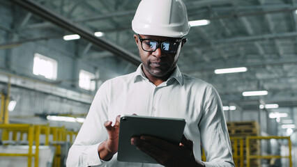 Responsible knowledgeable good-looking middle-aged African-American male employee walking going. Man tapping typing putting information in brand-new great stylish gadget tablet.