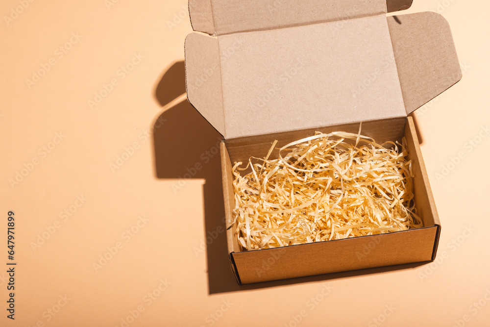 Poster open box with straw lining and copy space over cream background