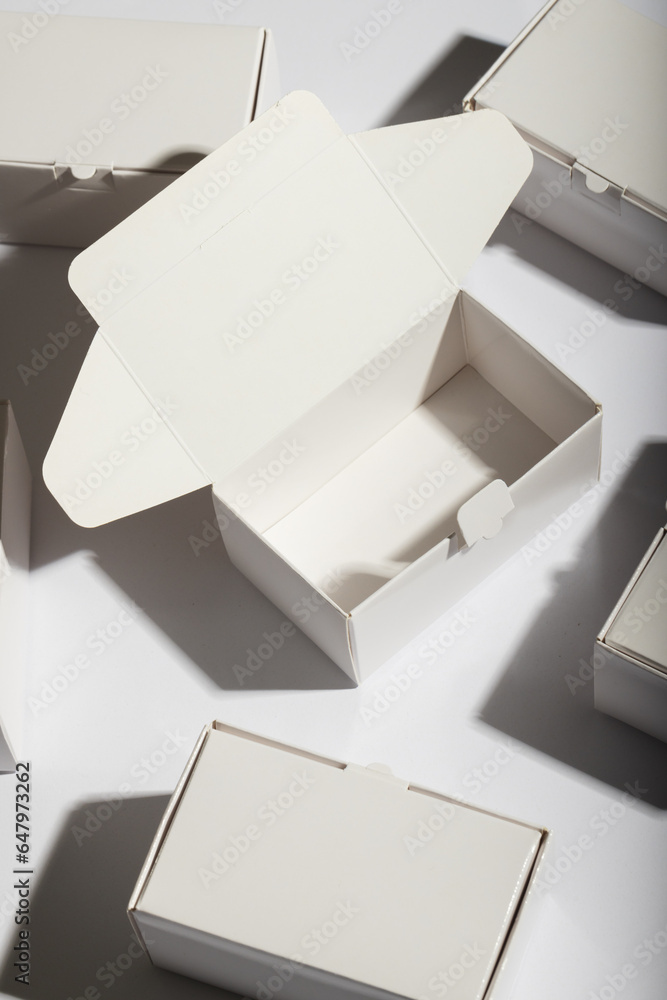 Poster vertical image of open cardboard gift box and boxes with copy space over white background