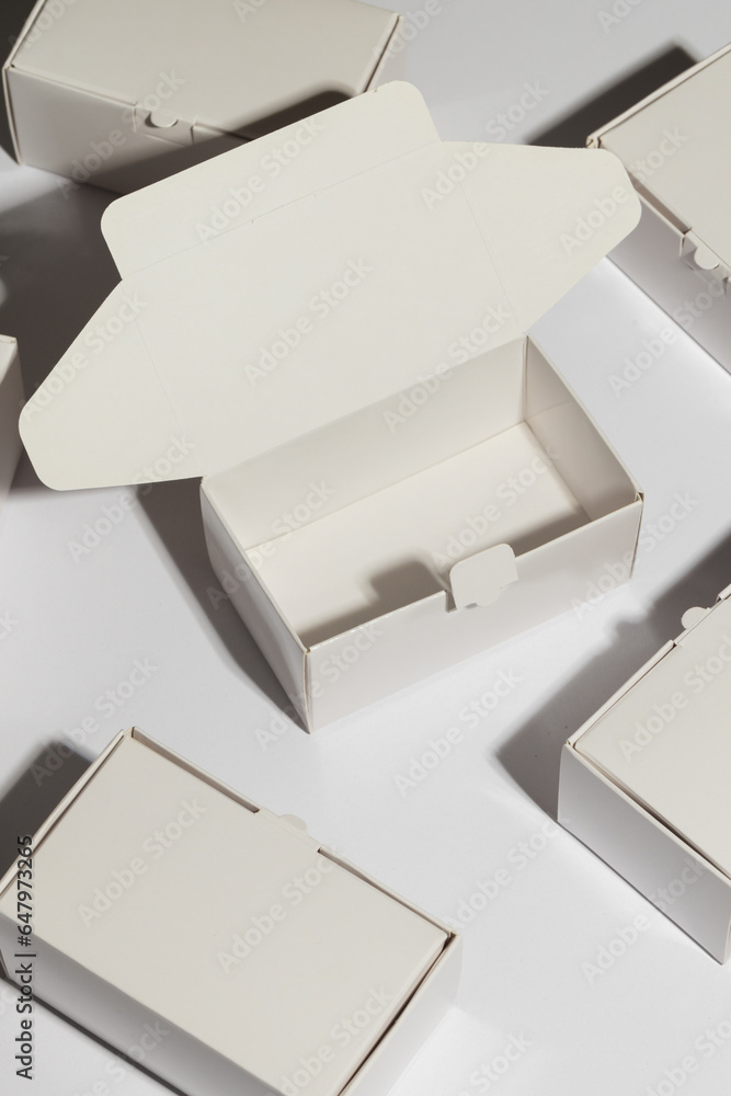 Poster vertical image of open cardboard gift box and boxes with copy space over white background