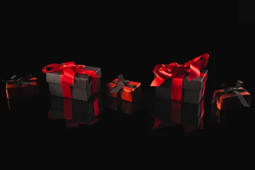 Schilderijen op glas Black and red gift boxes with ribbon and copy space over black background © vectorfusionart