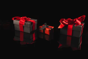  Black and red gift boxes with ribbon and copy space over black background © vectorfusionart