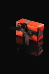 Poster Red gift box with ribbon and copy space over black background © vectorfusionart