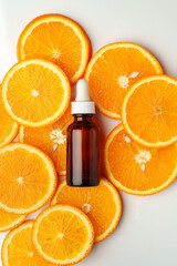Glass bottle of essential citrus oil on oranges background