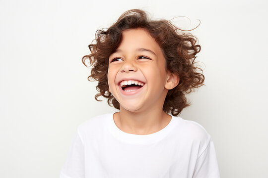  Studio portrait of cute little laughing boy on different colour background