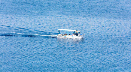 The yacht floats on the blue water of the sea. View from above