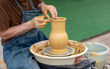 Clay craftsman sculpts crockery . Close-up.