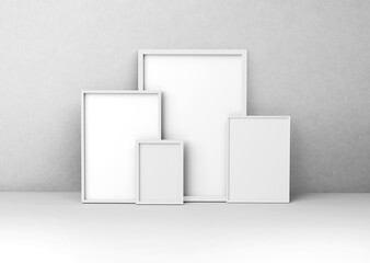 White plain empty blank five different sizes of vertical photo picture frames in front of textured concrete wall 