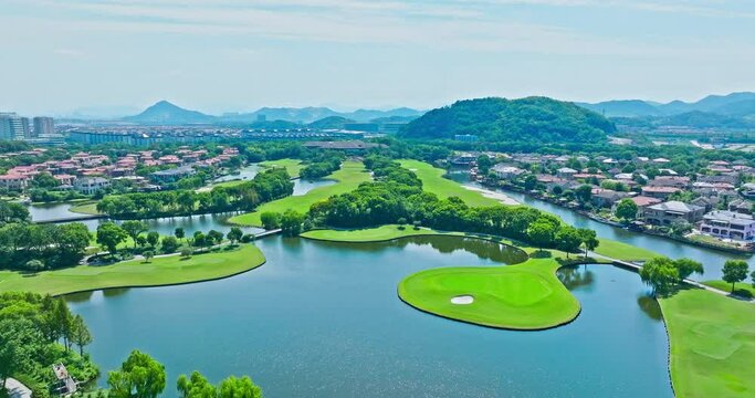 Aerial view of golf course and residential area buildings scenery in Shaoxing, Zhejiang Province, China. Green grass and mountain nature landscape.
