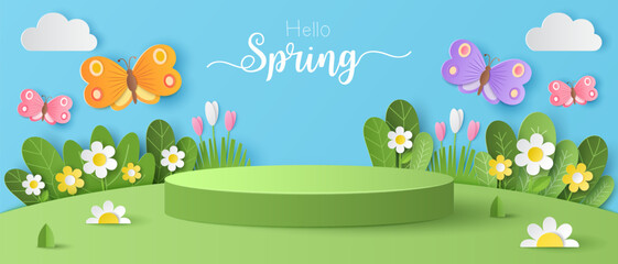 Paper cut of field of flowers and flocks of butterfly on blue sky background with green cylinder podium for your products display presentation. Hello spring.