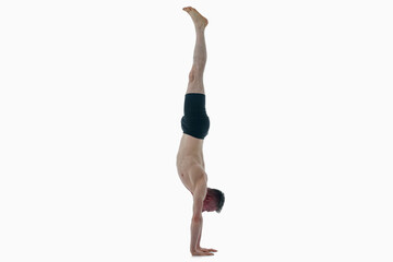 Adho Mukha Vrksasana (Downward facing tree pose), Ashtanga yoga  Side view of man wearing...