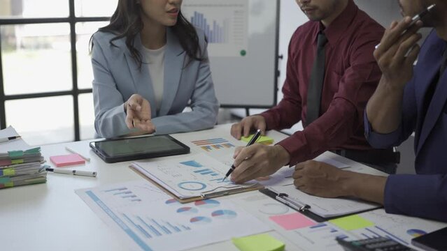 Business conference room with people sharing documents with pie charts and statistics Tablet and laptop working together in project brainstorming meeting Cooperate and work as a team