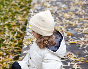 Baby girl are walking in the autumn city park. Little child having fun outdoors. Autumn season. Childhood