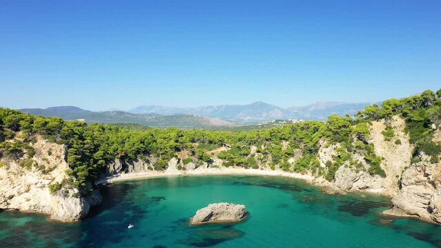 The golden sand beach of Alonaki Fanariou in the middle of its green rocky cliffs, in Europe, in Greece, in Epirus, towards Igoumenitsa, on the edge of the Ionian Sea, in summer, on a sunny day.&nbsp;
