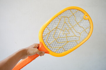 Asian man's hand holding a mosquito racket isolated on white background.