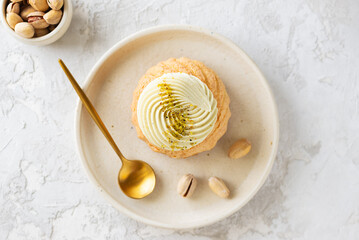 Choux cake with pistachio cream and nuts, French dessert shu. Top view.